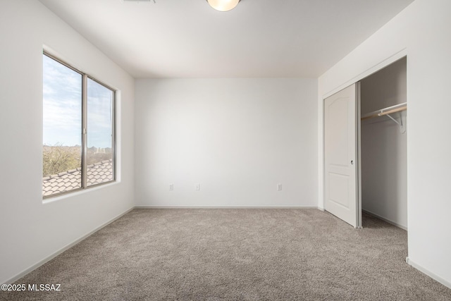 unfurnished bedroom with carpet, baseboards, and a closet