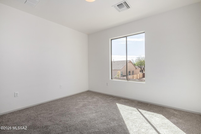 empty room featuring carpet, visible vents, and baseboards