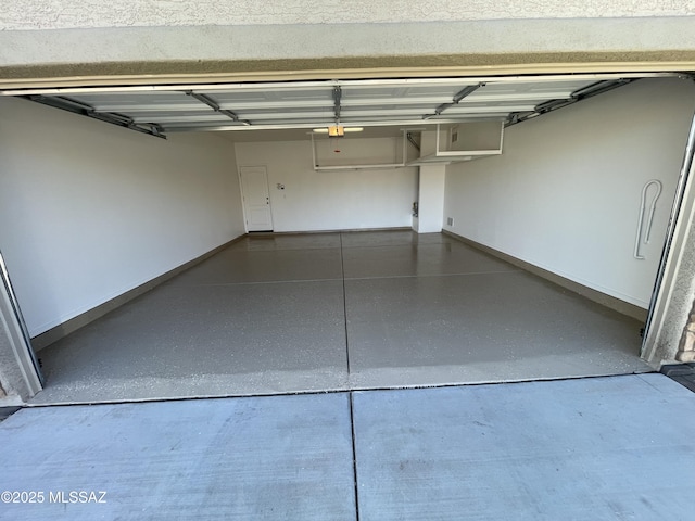 garage with baseboards and a garage door opener