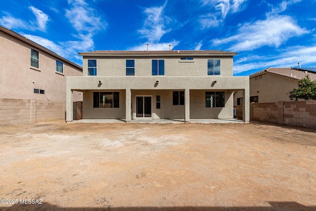 rear view of house with a patio, a fenced backyard, and stucco siding