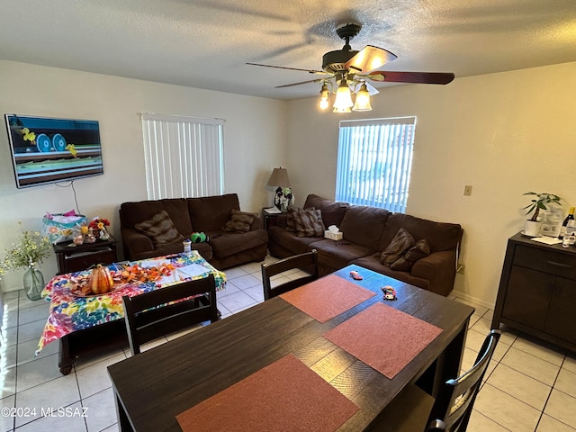 tiled dining area with a textured ceiling and ceiling fan