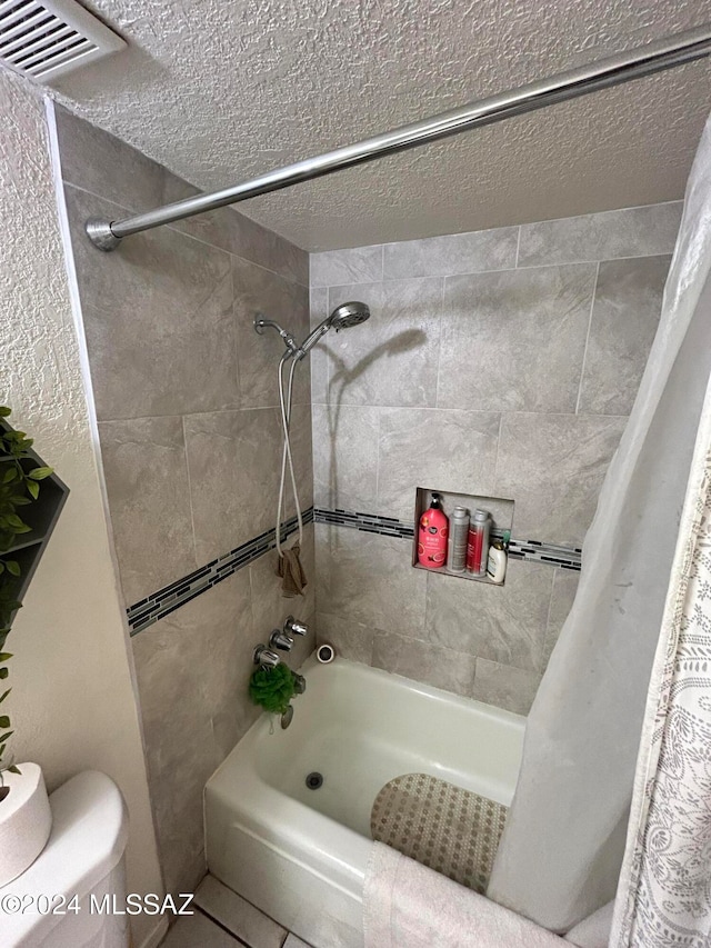 bathroom with shower / bath combo, a textured ceiling, and toilet