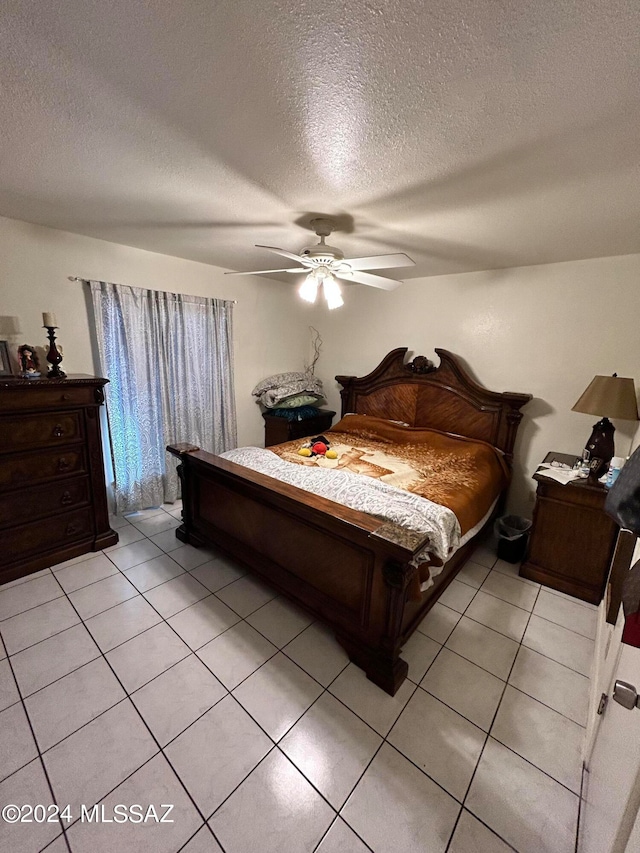 bedroom featuring a textured ceiling, light tile patterned flooring, and ceiling fan