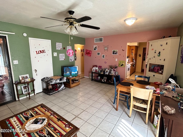 interior space featuring ceiling fan, a textured ceiling, and light tile patterned flooring