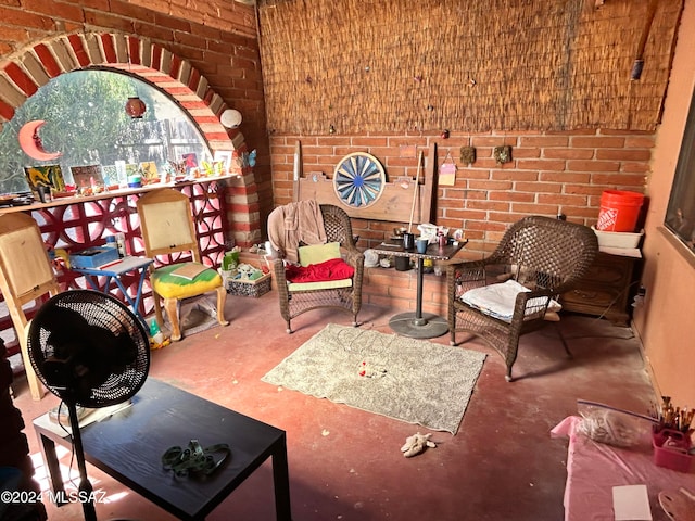 living area with concrete floors and brick wall