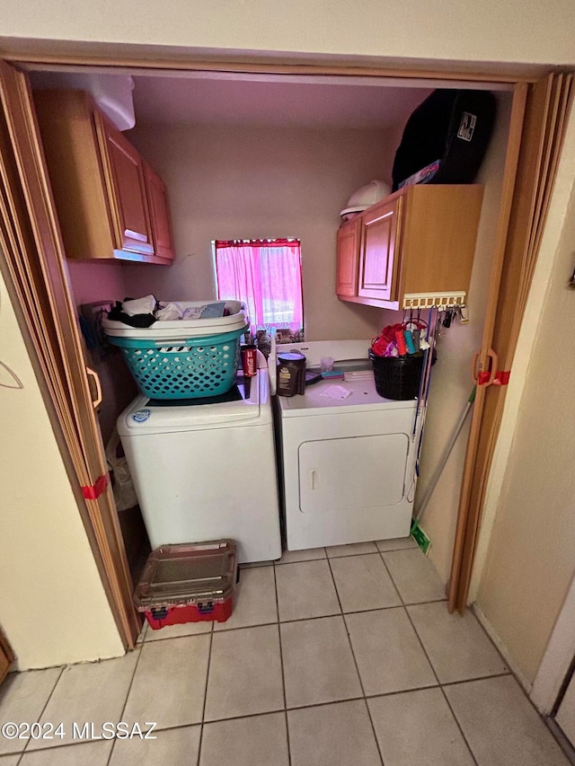 laundry area with cabinets, light tile patterned flooring, and washing machine and clothes dryer