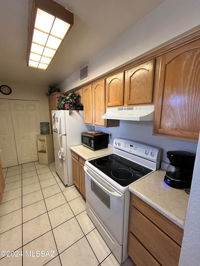 kitchen featuring light tile patterned floors and white appliances