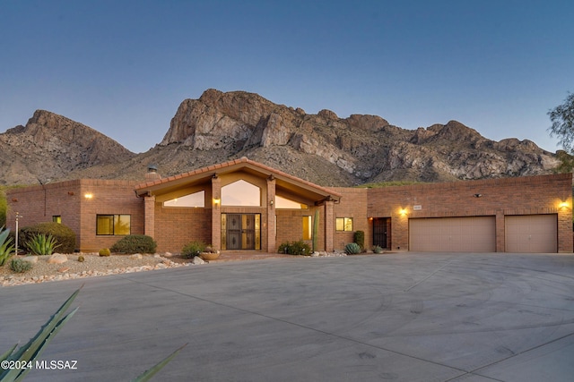 pueblo revival-style home with a mountain view and a garage