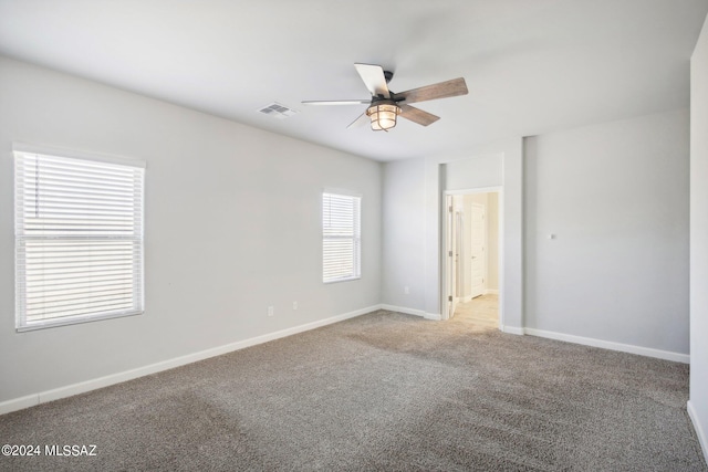 carpeted spare room with ceiling fan