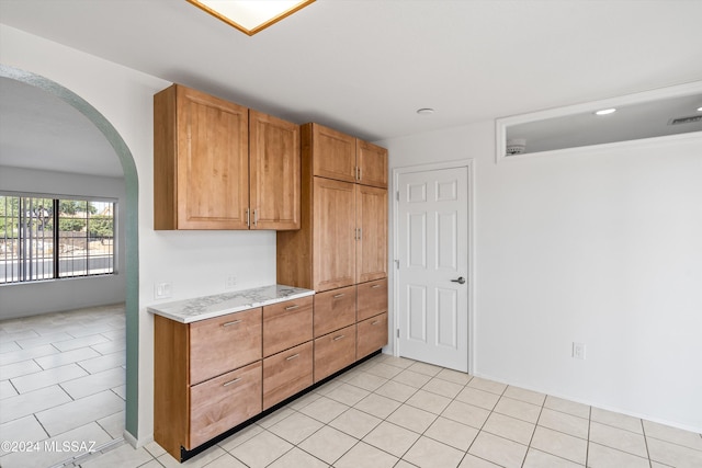 kitchen with light stone counters and light tile patterned floors