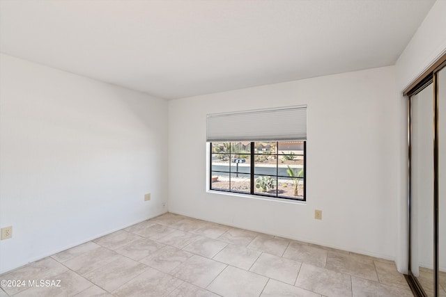 unfurnished bedroom with a closet and light tile patterned flooring