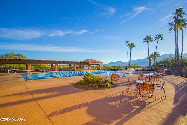 view of swimming pool with a patio and a mountain view