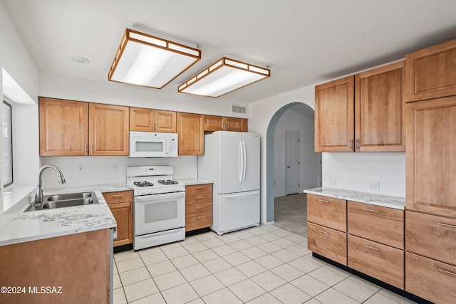 kitchen featuring sink, light tile patterned floors, and white appliances