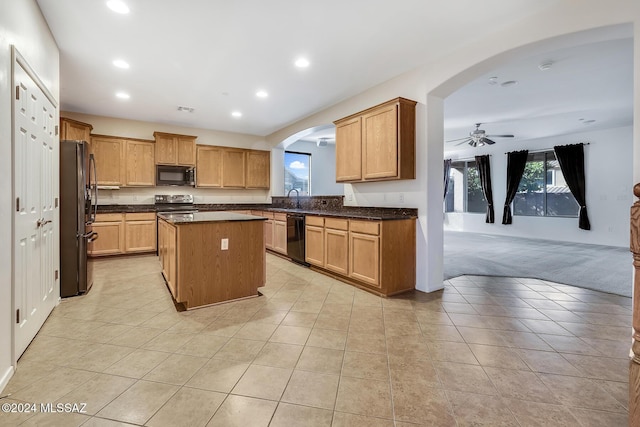 kitchen featuring light colored carpet, ceiling fan, sink, black appliances, and a kitchen island