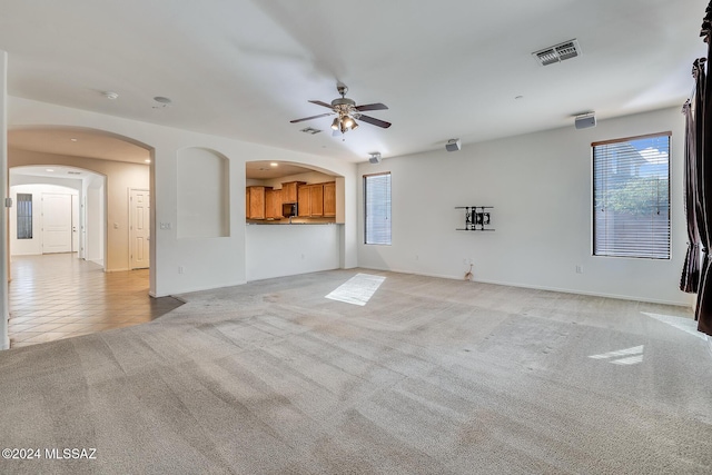 unfurnished living room featuring light tile patterned floors and ceiling fan