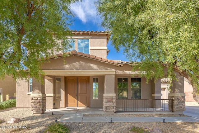 mediterranean / spanish-style house with covered porch