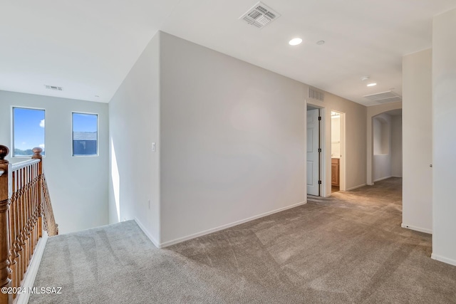 hallway featuring light colored carpet