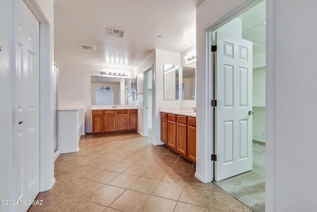 bathroom featuring tile patterned floors, vanity, and a shower with shower door