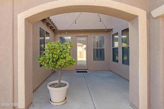 view of exterior entry with a patio area