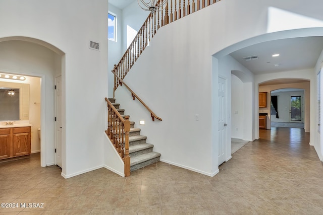 staircase with a towering ceiling and sink