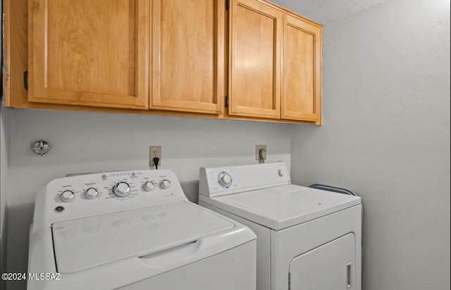 laundry room with independent washer and dryer, cabinets, and a textured ceiling