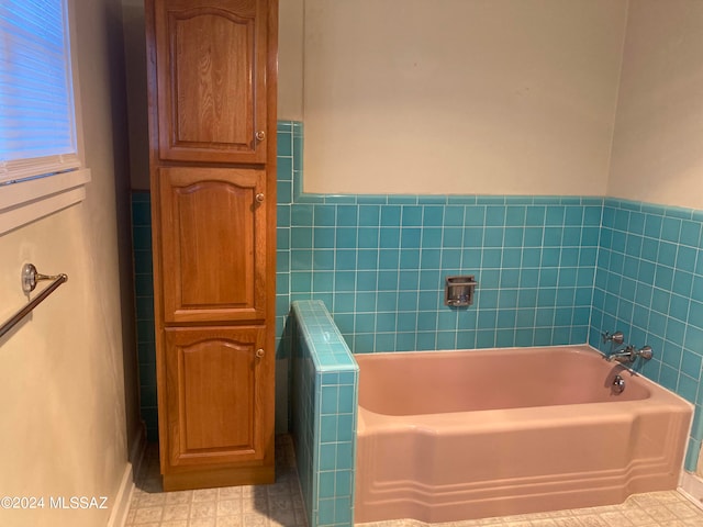 bathroom featuring tile walls, a bath, and tile patterned flooring