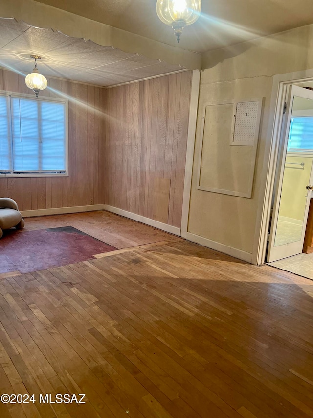 empty room with wooden walls and wood-type flooring