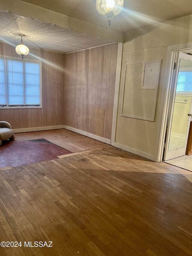 172 S Austin Blvd, Willcox, AZ 85643 - unfurnished room with hardwood / wood-style floors, wooden walls, and baseboards