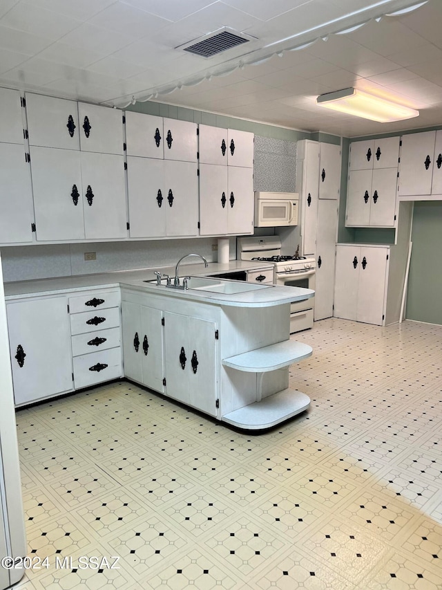 kitchen with sink, white cabinetry, and white appliances