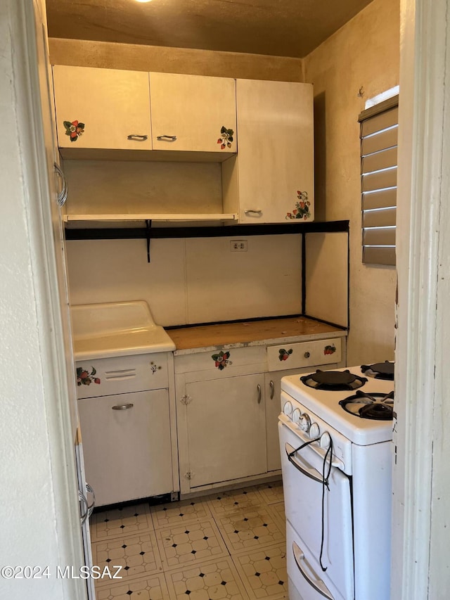 172 S Austin Blvd, Willcox, AZ 85643 - kitchen featuring light countertops, white range with gas cooktop, open shelves, and light floors