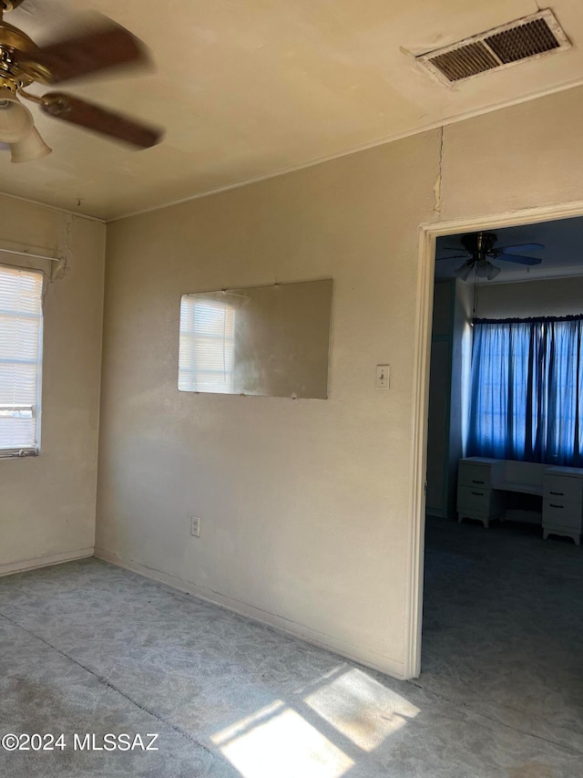 carpeted spare room with ceiling fan