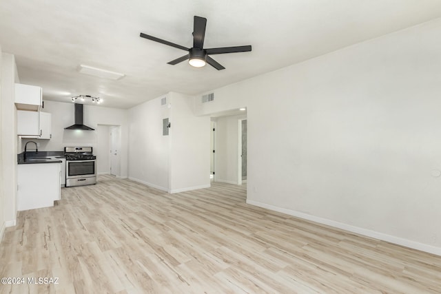 unfurnished living room featuring light wood-type flooring, ceiling fan, and sink