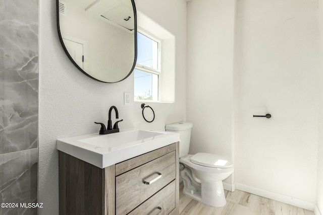 bathroom with hardwood / wood-style floors, toilet, and vanity