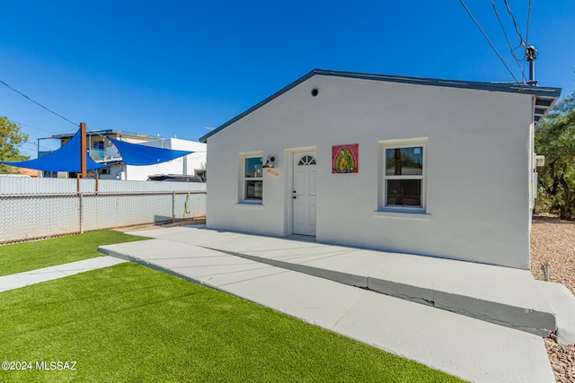 back of house featuring a patio and a lawn