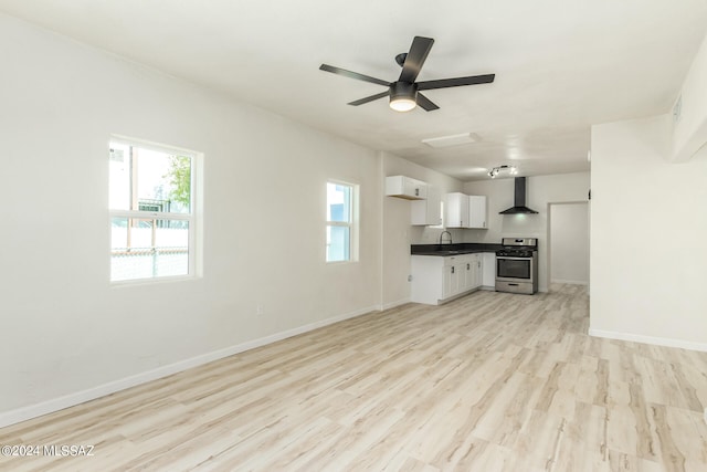 unfurnished living room featuring ceiling fan, light hardwood / wood-style floors, and a healthy amount of sunlight