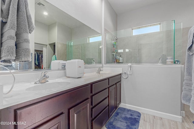 bathroom featuring vanity, a tile shower, and hardwood / wood-style flooring