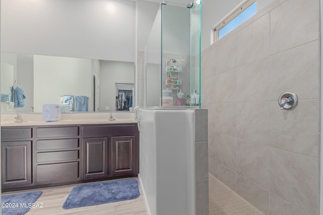 bathroom with vanity, hardwood / wood-style floors, and a tile shower