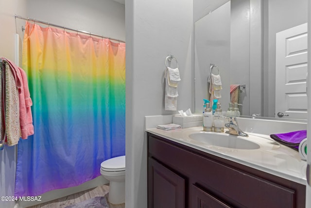 bathroom featuring vanity, toilet, and walk in shower