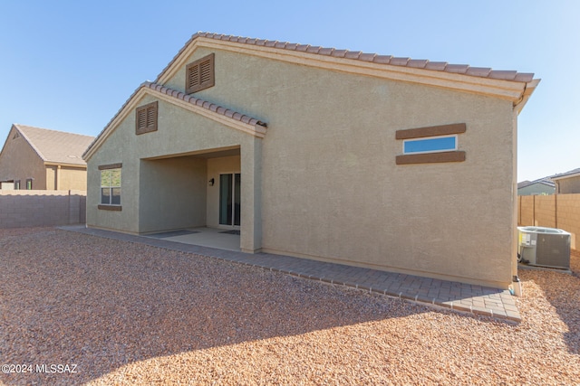 back of property with central air condition unit and a patio area