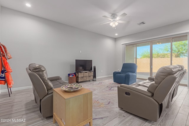 living room featuring light hardwood / wood-style flooring and ceiling fan