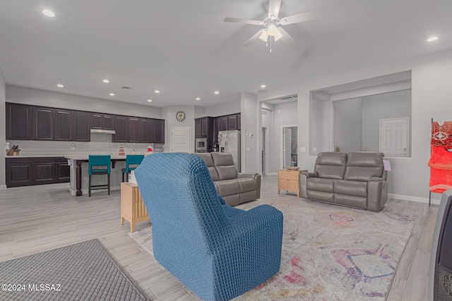 living room featuring light hardwood / wood-style floors and ceiling fan