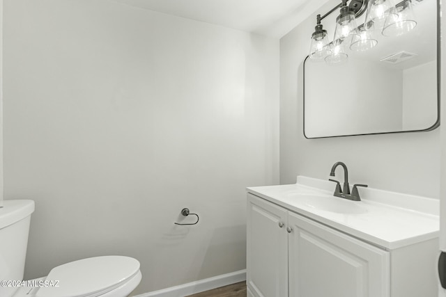 bathroom featuring vanity, hardwood / wood-style floors, and toilet