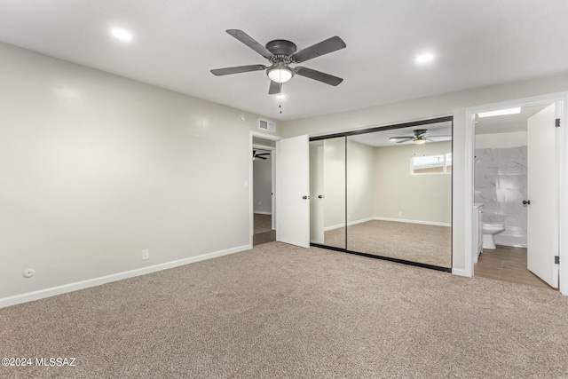 unfurnished bedroom featuring carpet floors, a closet, connected bathroom, and ceiling fan