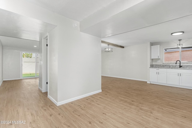 unfurnished living room with sink and light wood-type flooring