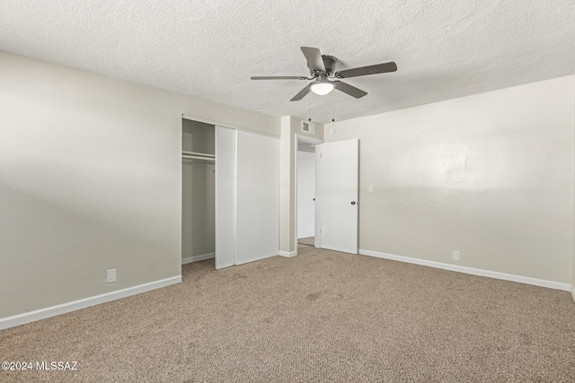 unfurnished bedroom with ceiling fan, a closet, carpet, and a textured ceiling