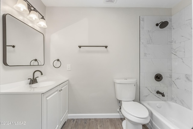 full bathroom featuring hardwood / wood-style flooring, toilet, vanity, and tiled shower / bath combo