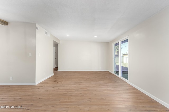 empty room featuring light hardwood / wood-style floors and a textured ceiling