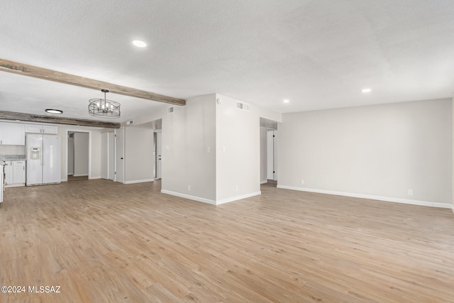 unfurnished living room with light hardwood / wood-style floors, beam ceiling, and a notable chandelier