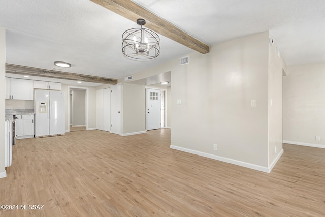 unfurnished living room with a textured ceiling, light wood-type flooring, a chandelier, and beam ceiling