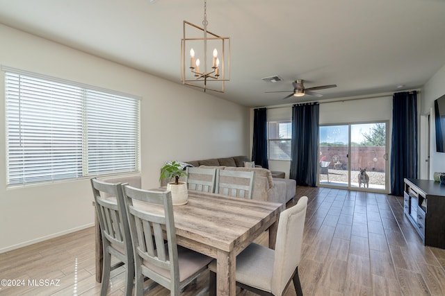 dining room with hardwood / wood-style floors and ceiling fan with notable chandelier